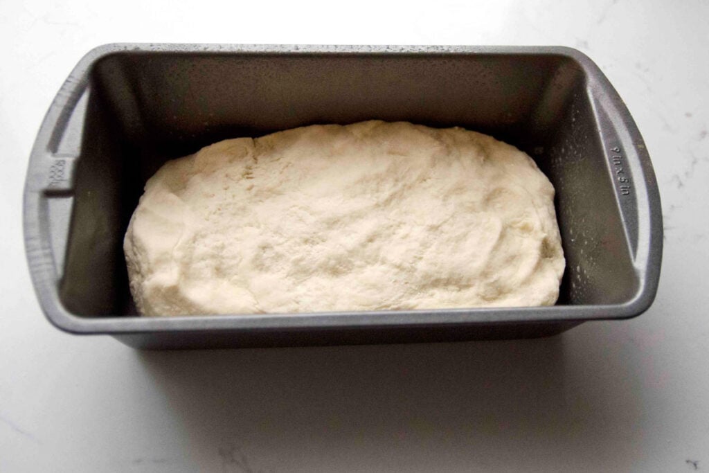 Bread dough sits in a pan waiting to rise.