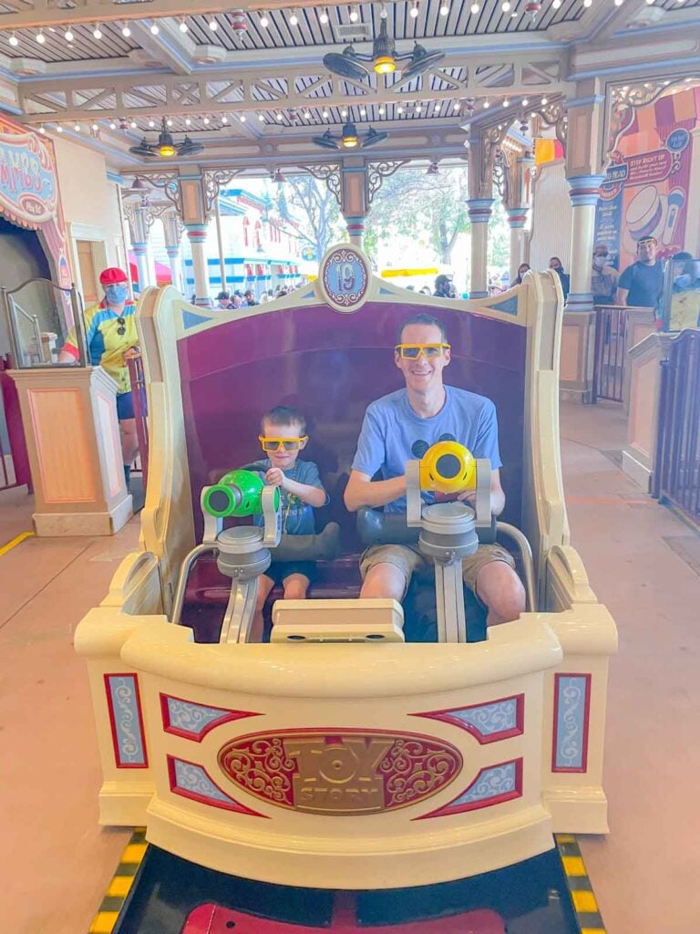 A father and son sit together on the Toy Story Mania ride at DCA.