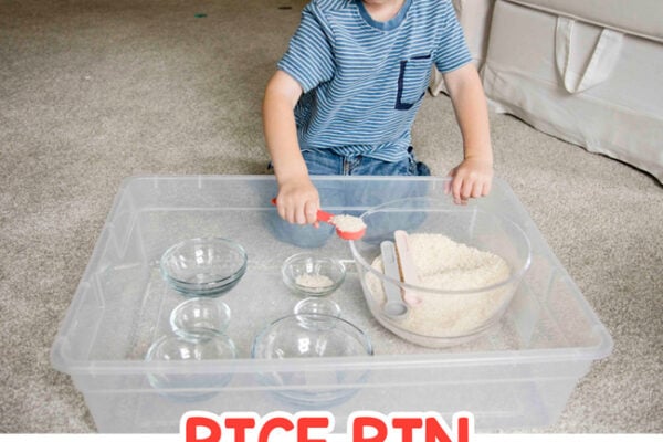 RICE BIN TODDLER ACTIVITY - A toddler playing with a simple scoop and transfer activity inspired by Montessori at home play in a quick and easy activity from Busy Toddler