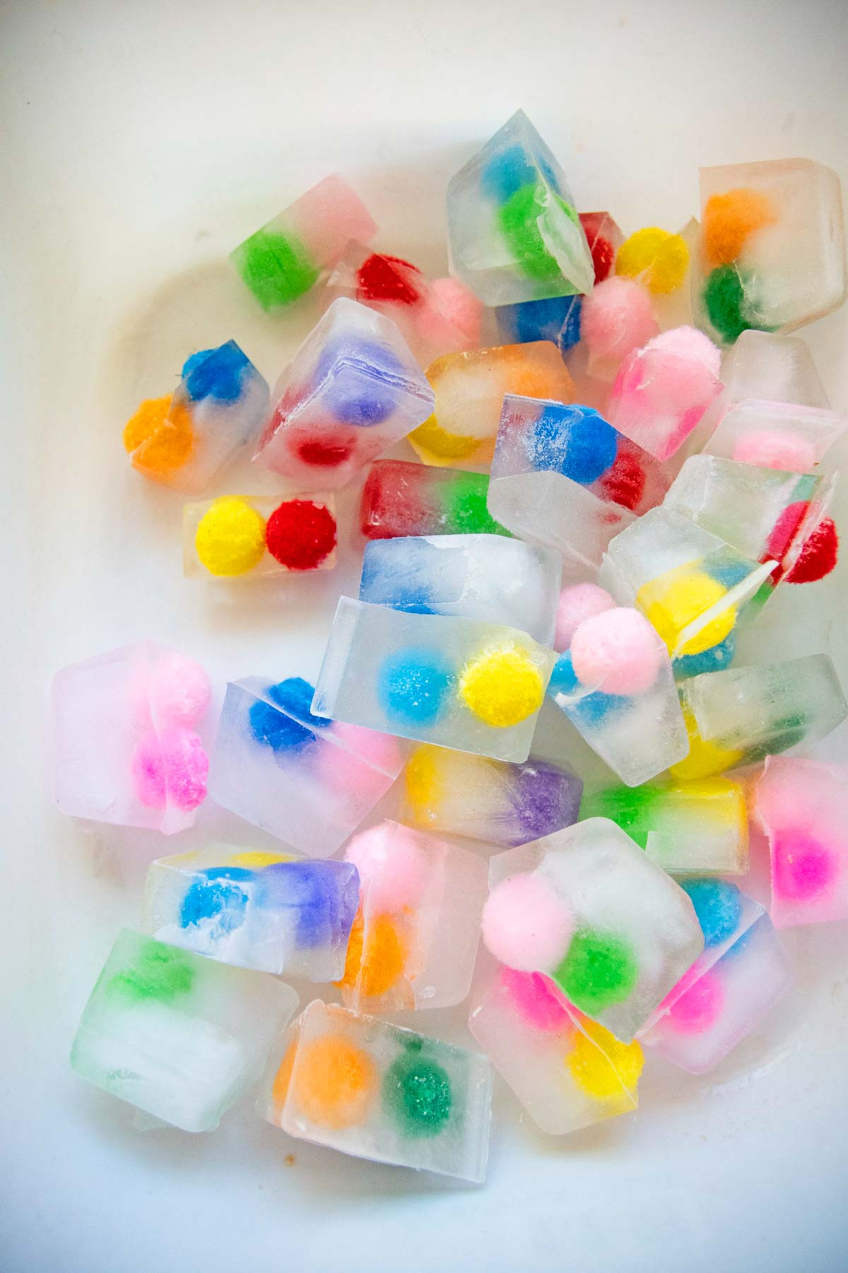 A container of pom pom balls frozen into ice cubes.