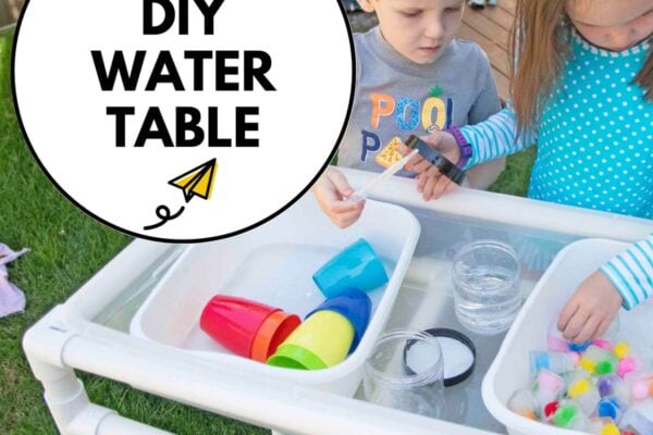 How to make a PVC Pipe Water Table: two children are playing at a DIY water table.