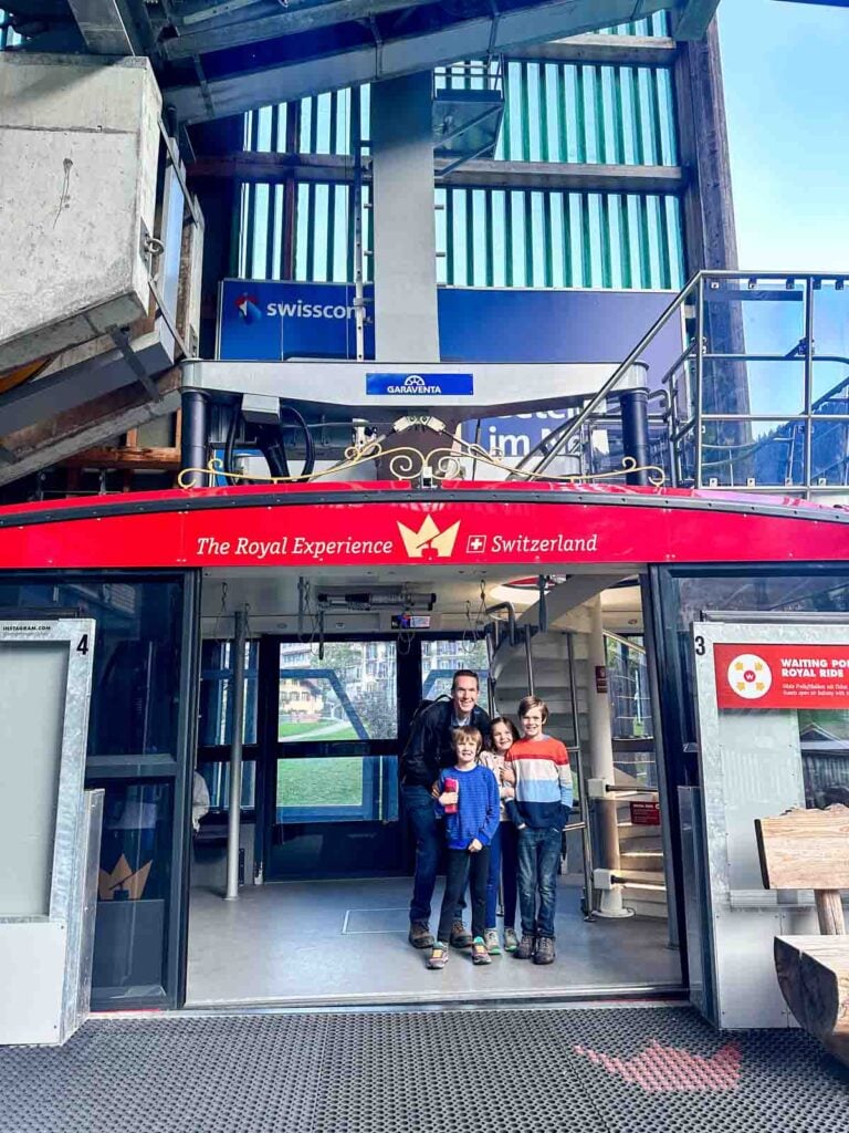A family stands in the doorway of an aerial tram.