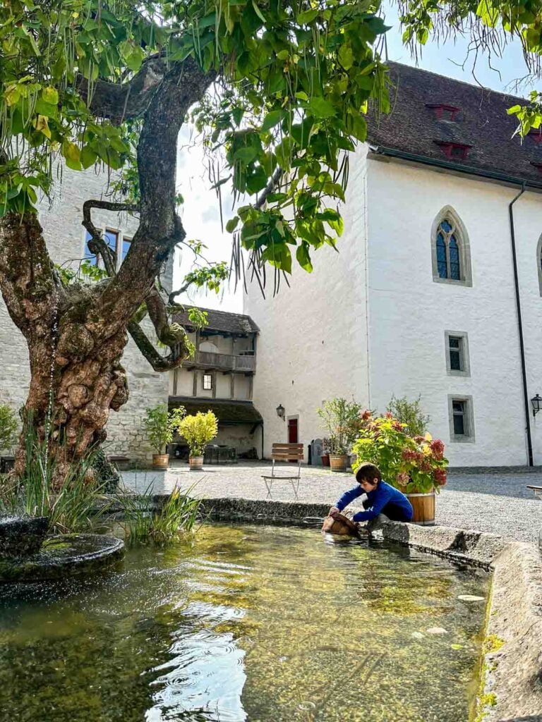 A child fetches water for a working well in Switzerland.