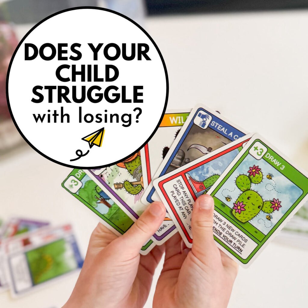 DOes you child struggle with losing games? Image shows a child's hands with playing cards.