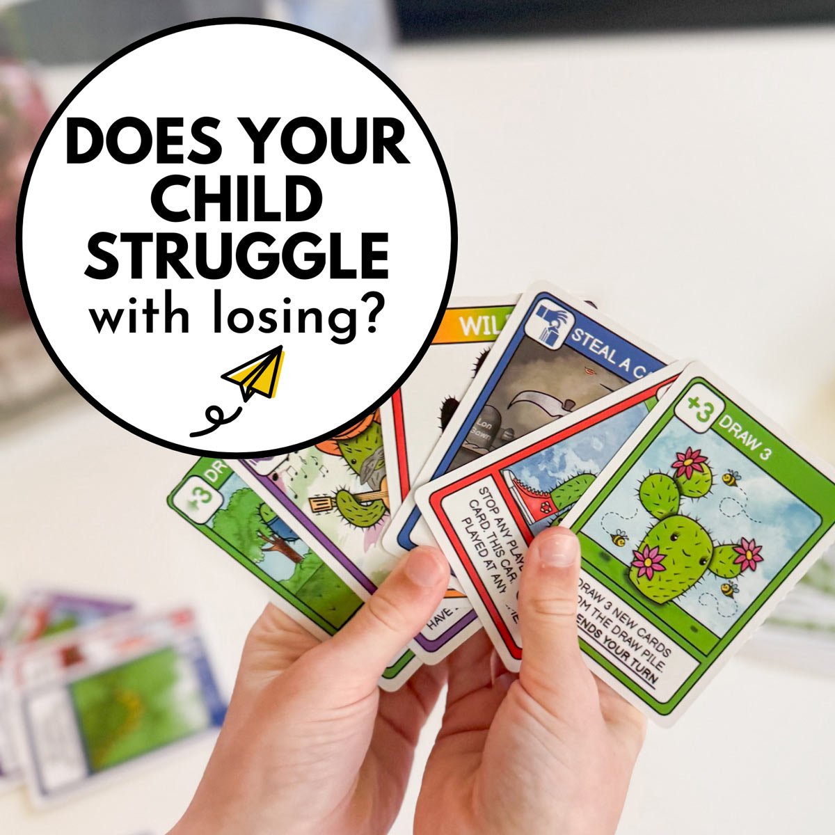 DOes you child struggle with losing games? Image shows a child's hands with playing cards.