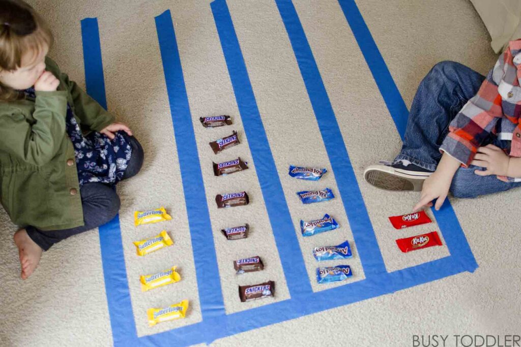 Two preschoolers create a graph with candy,