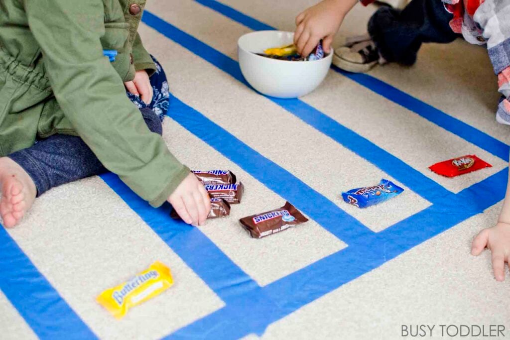 Two preschoolers create a graph with candy,