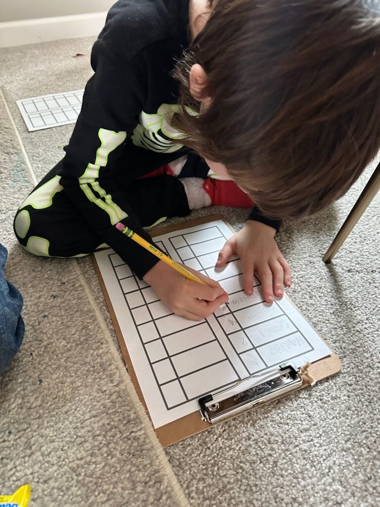 A child tallying candy onto paper.