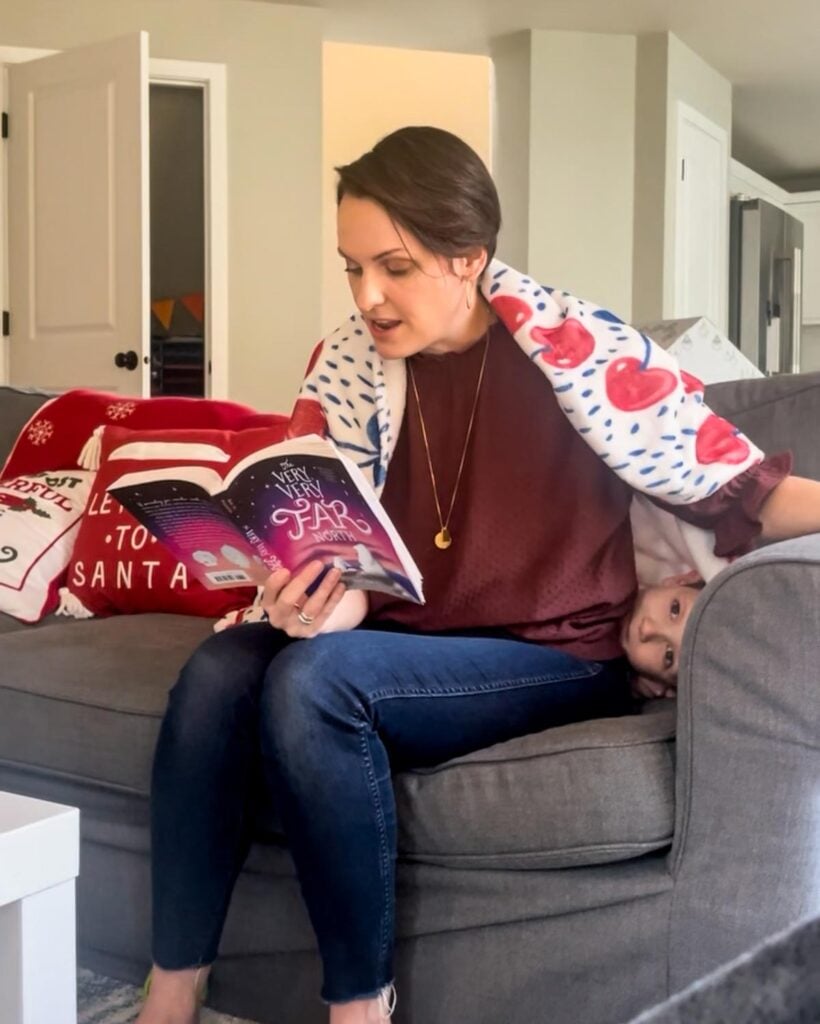 A mom holds "the Very Very Far North" during a read aloud while a child hides behind her